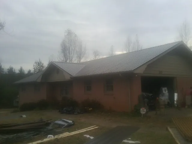 Gray metal roof on a stucco house with an attached garage in Buffalo