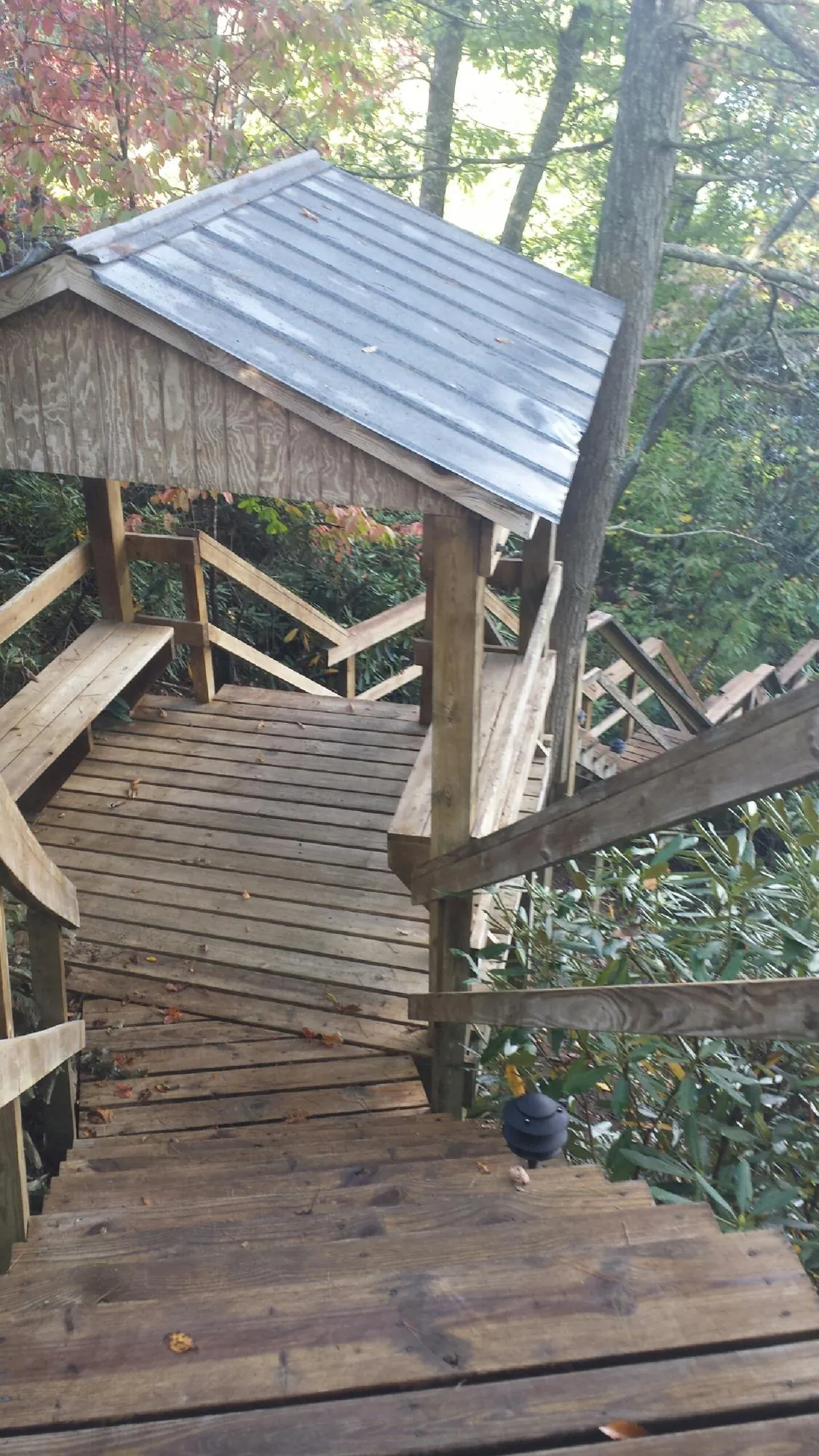 Metal roofed shelter over wooden steps on a wooded walkway — Skylight Repair & Installation work by our crew in Buffalo